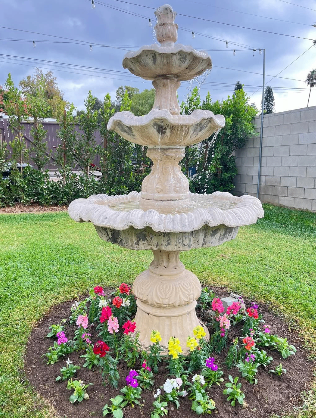 Decorative fountain and seasonal flower planting at a completed property enhancement project